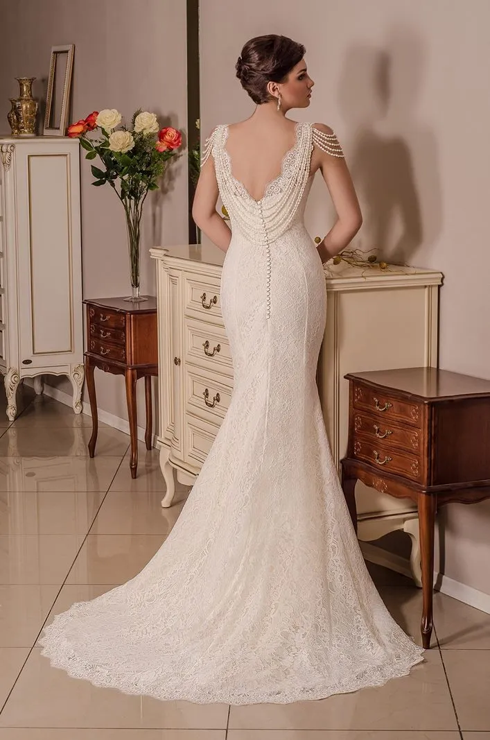 ---Mermaid wedding dress made of satin and lace with embroidered straps and decorated with dangling jewels--